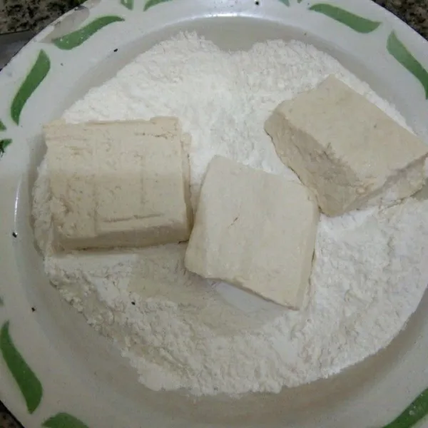Gulingkan tahu pada adonan tepung, lakukan hingga habis
