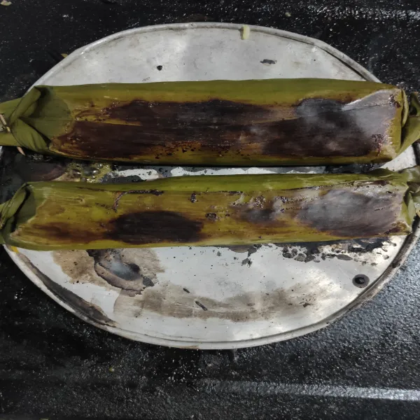 Setelah ikan matang, panggang di atas kompor atau teflon dengan api kecil hingga daun sedikit terbakar (aku pakai bekas tutup kaleng biskuit).