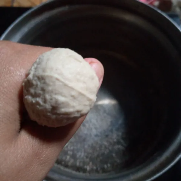 Panaskan air dalam panci,lalu matikan,ambil sedikit adonan bentuk bulat bakso dengan tangan lalu ambil dengan sendok.