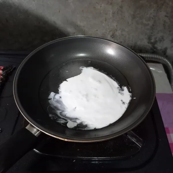 Masukkan ke dalam wajan gula pasir, air, dan santan. Masak dengan api kecil sampai gula larut.