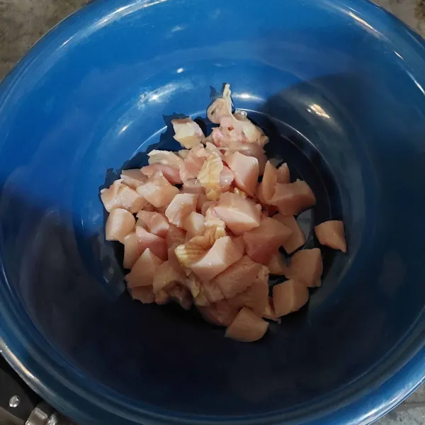Pisahkan daging ayam dengan tulangnya, lalu potong dadu.