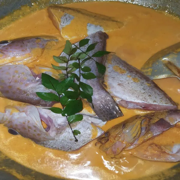 Setelah itu masukkan ikan dan juga daun kari. Aduk pelan hingga semua ikan tenggelam dalam kuah santan.