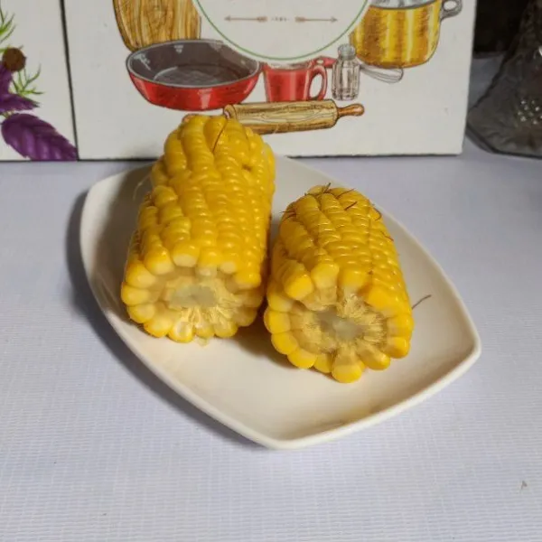 Rebus jagung sampai matang. Kemudian serut atau pipil jagung.