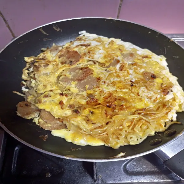 Tunggu sampai matang merata lalu angkat. Omelette mie siap disajikan bersama saus kesukaan.