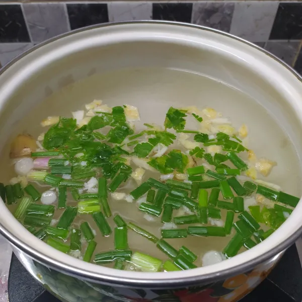 cincang bawang putih, masukkan dalam rebusan air, masukkan jahe, daun bawang dan seledri. rebus sampai mendidih.