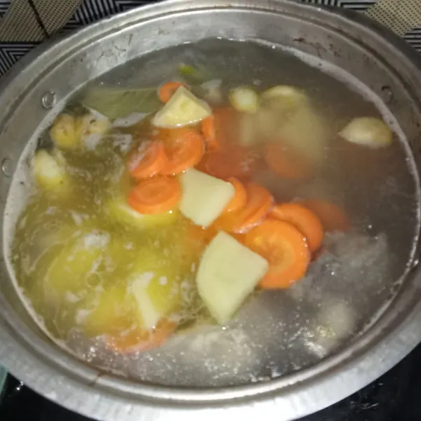 Masukkan wortel dan kentang, masak hingga ayam empuk.