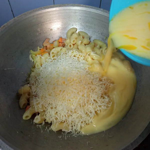 Tuangkan campuran susu dan telur, aduk kembali.