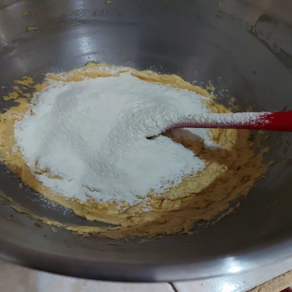 Tambahkan tepung, baking powder, dan soda kue. Aduk rata.