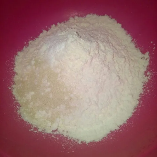 Siapkan wadah, campur jadi satu bahan kering yang terdiri dari tepung terigu, ragi, baking powder, garam. Aduk rata.