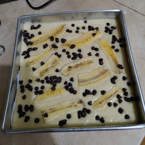 setelah 10 menit di oven,kelurkan lagi bolu pisang lalu beri toping irisan pisang dan chocochips