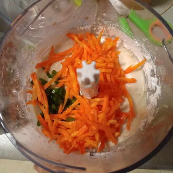 Tambahkan sebagian wortel parut dan daun bawang, lalu mixer sebentar.