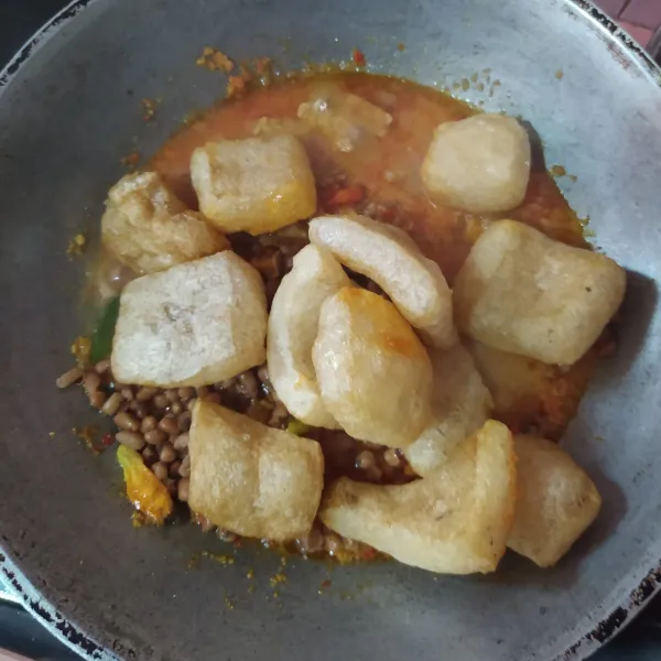 Masukkan krupuk krecek, kemudian tambahkan sisa airnya. Masak sampai krecek empuk. Jika krecek masih keras bagian dalamnya, tambahkan air.