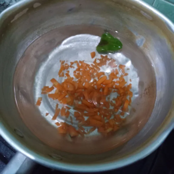 Didihkan air bersama wortel dan daun jeruk.