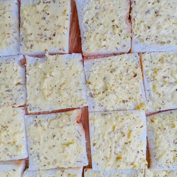 Oleskan campuran margarin , bawang putih dan oregano/basil ke atas roti.