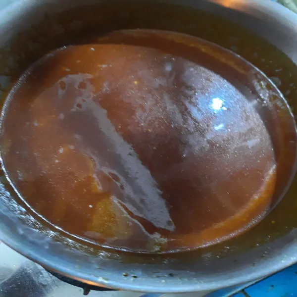 Masak air sampai panas kemudian masukkan secara perlahan adonan karamel gula tadi, hati-hati timbul letupan.