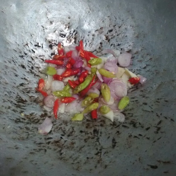 Tumis minyak baceman bawang putih bersama bawang merah, bawang putih, potongan cabe, daun salam dan lengkuas hingga harum