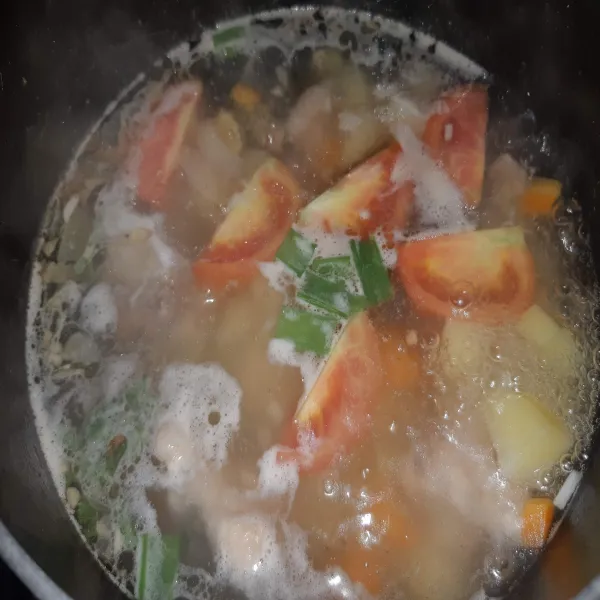 Setelah ayam matang dan sayuran empuk. Beri tomat dan bawang, masak hingga rasa pas.