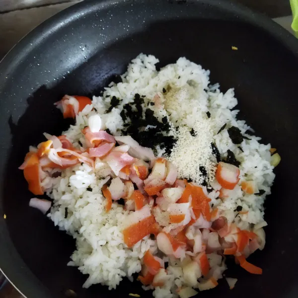 Panaskan sedikit minyak lalu tumis bawang putih. Masukkan nasi, crab stick, nori, garam dan kaldu jamur, aduk rata lalu tes rasa.