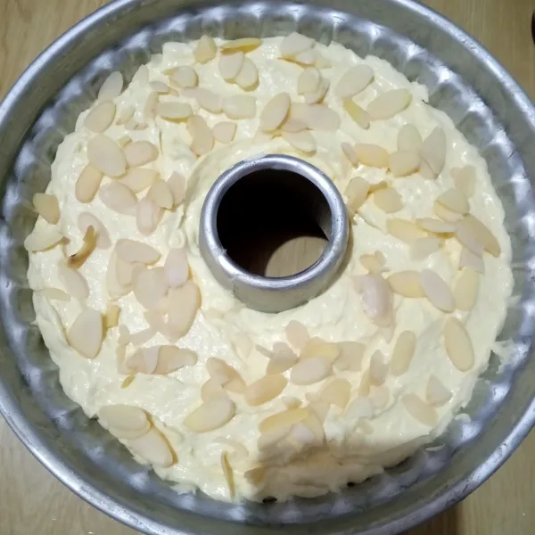 Tuang ke dalam loyang yang sudah di olesi margarin atau carlo, lalu hentakkan beberapa kali dan taburi dengan almond slice.