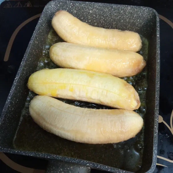 Panaskan margarin, bakar pisang sampai kuning kecokelatan.