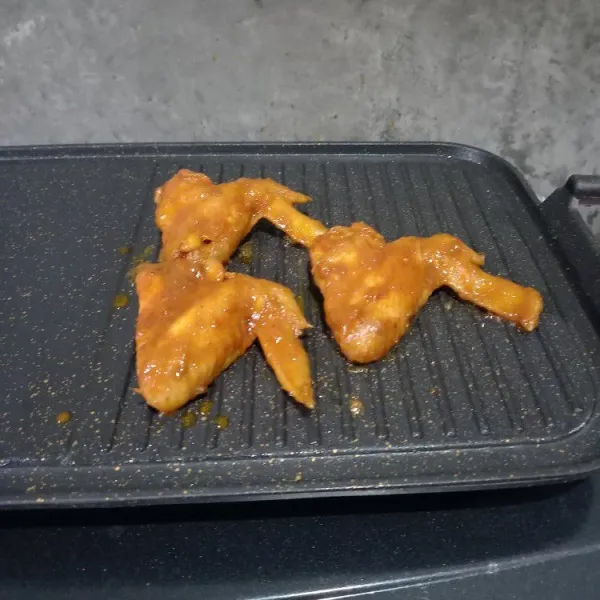 Bakar ayam dan olesi dengan sisa bumbu ayam. Sajikan sayap bakar dengan lalapan dan sambal kesukaan.