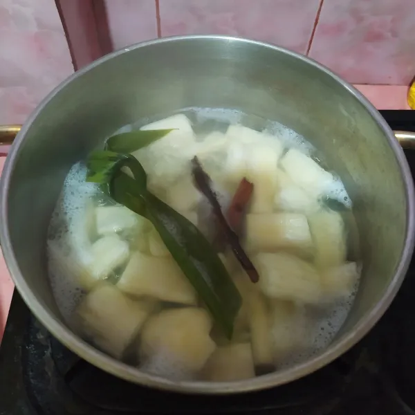 Rebus air, daun pandan dan kayumanis, lalu masukkan singkong. Masak hingga setengah empuk.