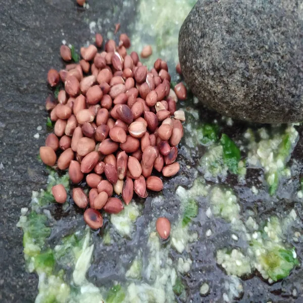 Masukkan kacang tanah dan daun jeruk, ulek halus.
