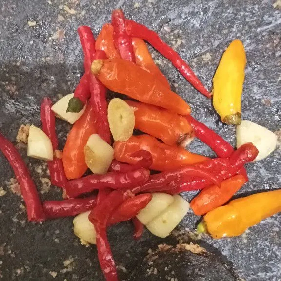 Goreng dulu cabe dan bawang putih sebelum dihaluskan. Setelah itu uleg hingga halus.