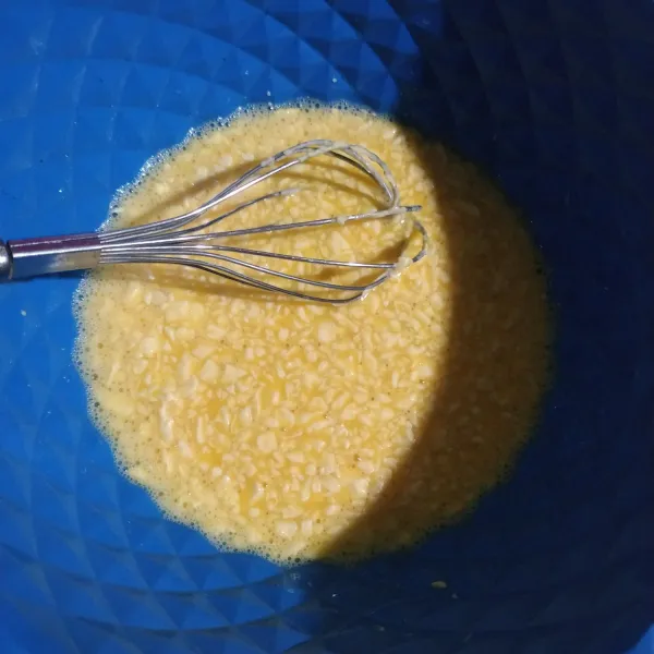 Dalam wadah, kocok telur dan margarin.