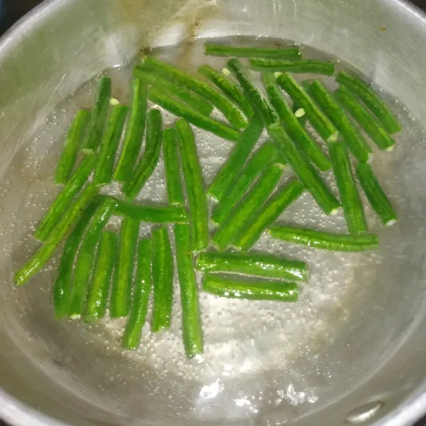 Masak air secukupnya hingga mendidih, lalu masukkan potongan kacang panjang. Masak sebentar sampai setengah matang.