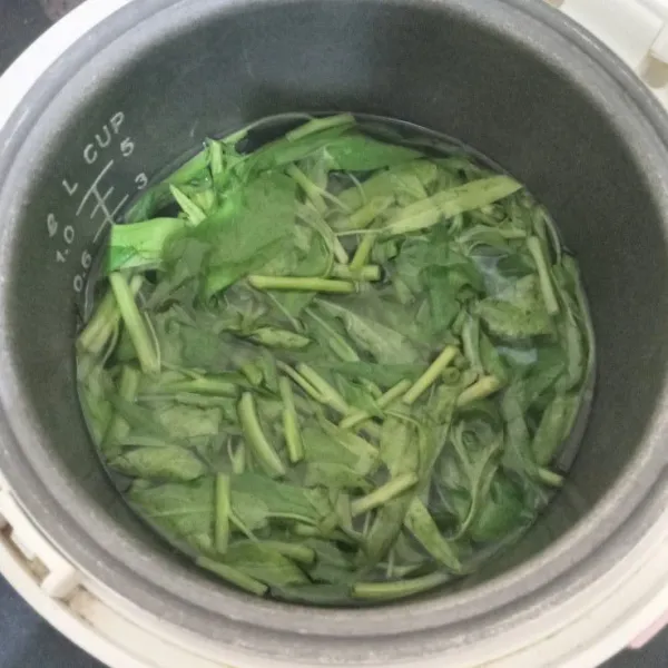Didihkan air dalam magic com (tombol cook menyala terus). Rebus kangkung sampai lunak/tingkat kematangan sesuai selera.
