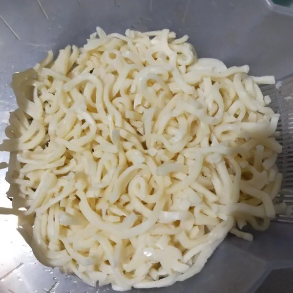 Uraikan udon, lalu cuci hingga bersih.