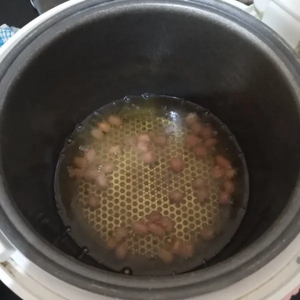 Panaskan minyak goreng dalam magic com (tombol cook menyala terus). Goreng kacang goreng hingga matang. Angkat dan tiriskan. Sisihkan.