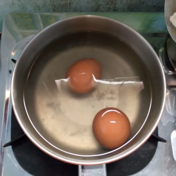 Rebus telur sampai matang. Angkat dan kupas.