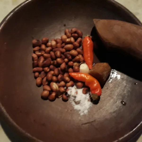Haluskan cabe rawit merah, kacang tanah sangrai dan garam.