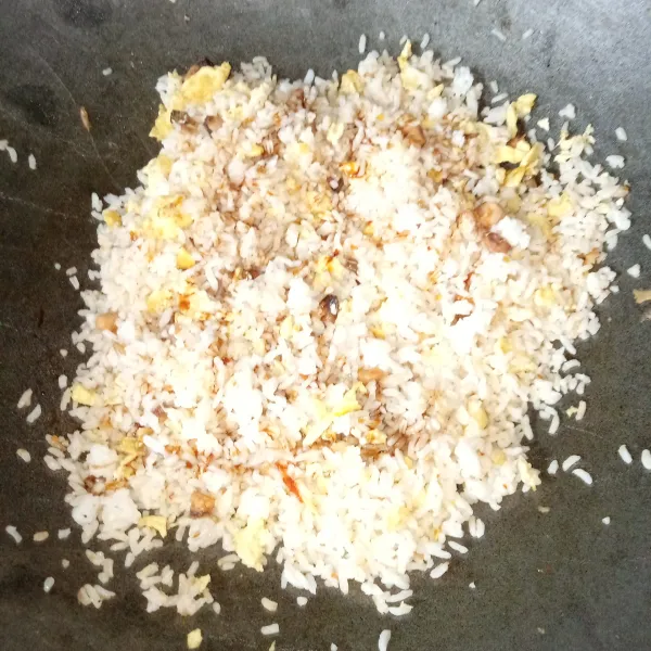 Masukkan nasi, aduk rata dengan bumbu, telur dan ikan asin, tambahkan saus tiram, kecap asin dan garam, aduk rata.