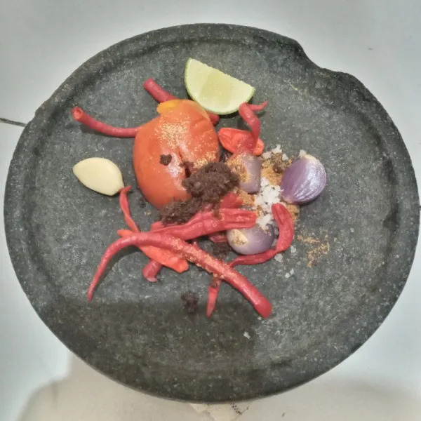 Pindahkan bahan sambal ke cobek. Tambahkan gula aren bubuk, garam kasar, kaldu bubuk dan terasi udang.