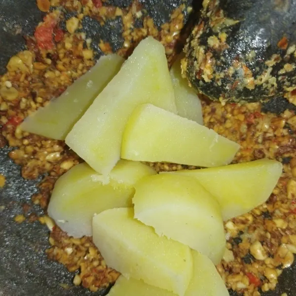 Tambahkan gula merah dan kentang rebus, ulek hingga halus dan tercampur rata.