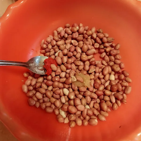 Cuci kacang hingga bersih dan pisahkan dari kacang busuk. Karena saya menggunakan bawang putih halus jadi langsung campur ke kacang bersamaan dengan cabai giling, aduk rata.