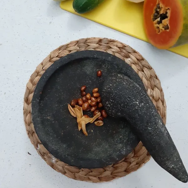 Haluskan kacang tanah dan bawang putih.