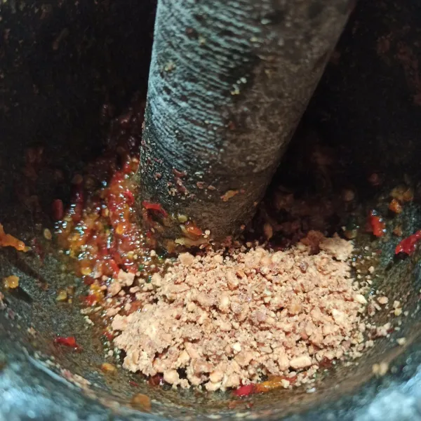 Setelah bumbu halus, masukkan sedikit demi sedikit kacang tanah yang sudah dihancurkan.