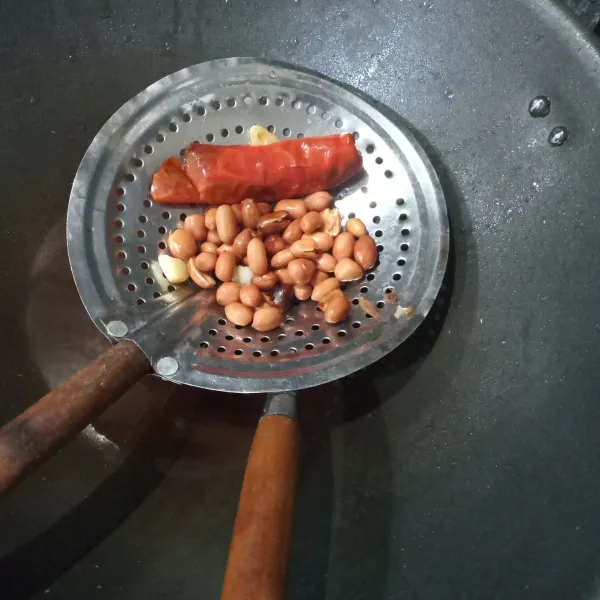 Goreng kacang tanah, cabai merah, kencur dan bawang putih.