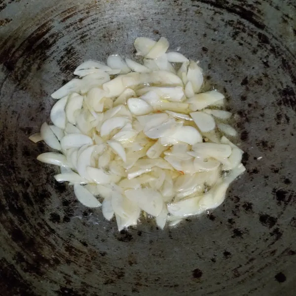 Tumis bawang putih sampai layu dan harum.