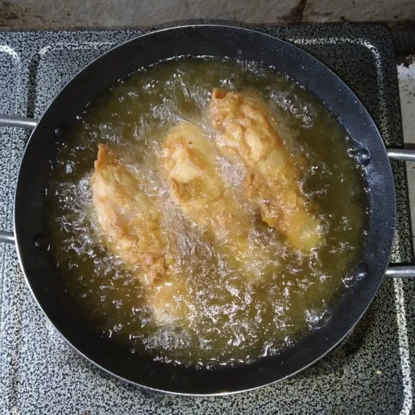 Panaskan minyak, goreng ayam dengan api sedang hingga kuning keemasan, pastikan ayam matang, tiriskan. Untuk hasil yang lebih krispi, ayam dapat digoreng 2 kali.