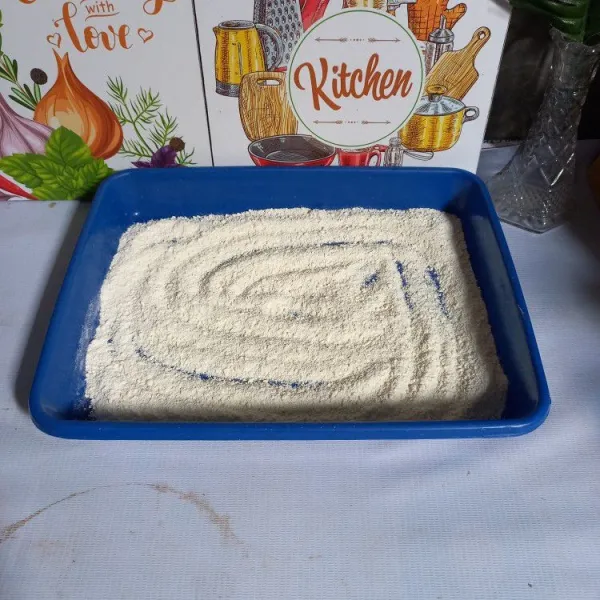 Siapkan tepung singkong pada wadah yang lebar.