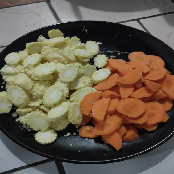 Bersihkan wortel dan jagung, kemudian potong bulat dan sisihkan.