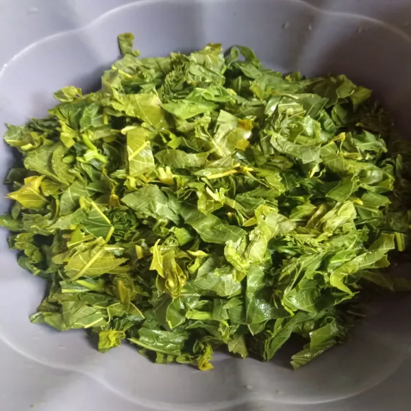 Didihkan air rebus daun singkong sampai lunak, lalu tambahkan sedikit garam. Lalu angkat, peras, dan potong-potong.