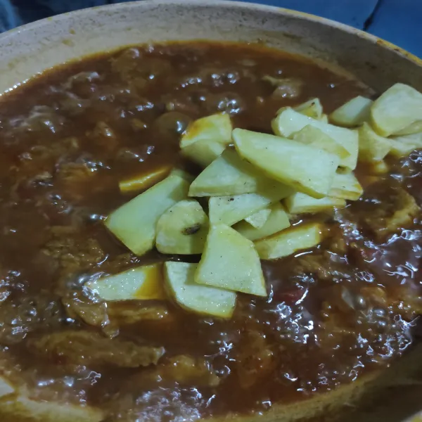 Masukkan kentang yang sudah digoreng, lalu aduk rata. Masak hingga mendidih, lalu angkat dan sajikan.