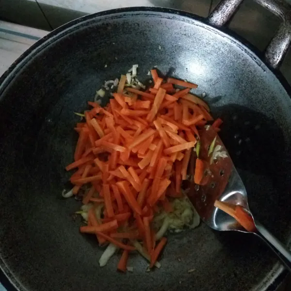 Masukkan wortel, aduk rata. Tambahkan air. Masak hingga wortel layu.