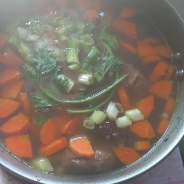 Masukkan wortel, masak sampai empuk, koreksi rasa jika sudah pas, masukkan seledri dan daun bawang lalu sajikan saat hangat.